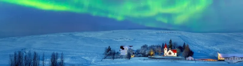 Nordlys over et snødekt landskap på Island.