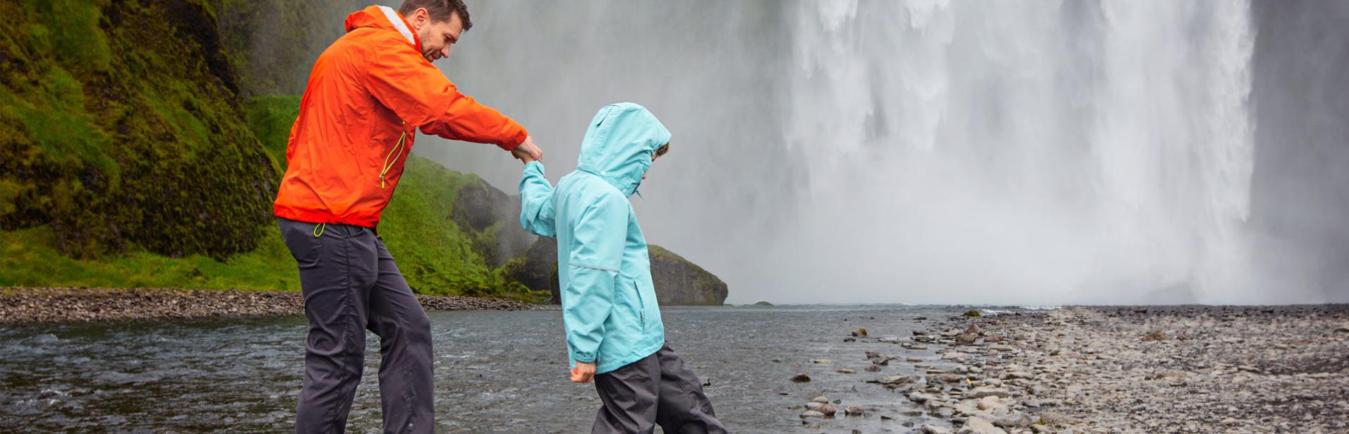 Far og sønn besøker fossen Skogafoss på Island