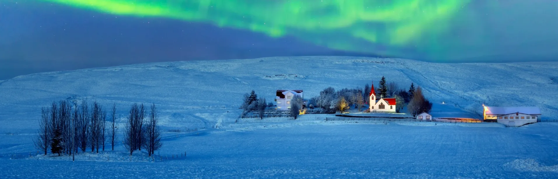 Nordlys over et snødekt landskap på Island.